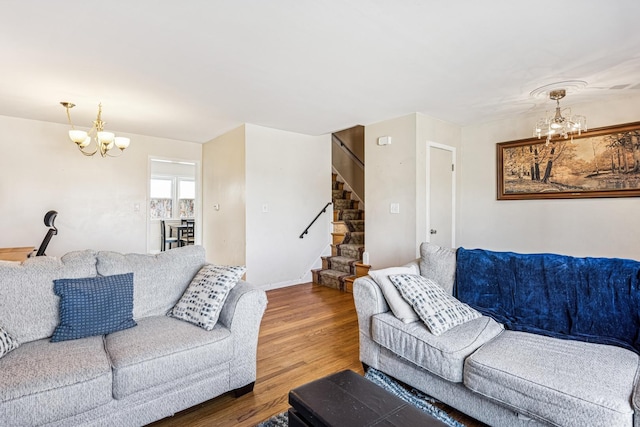 living area featuring a notable chandelier, stairway, and wood finished floors