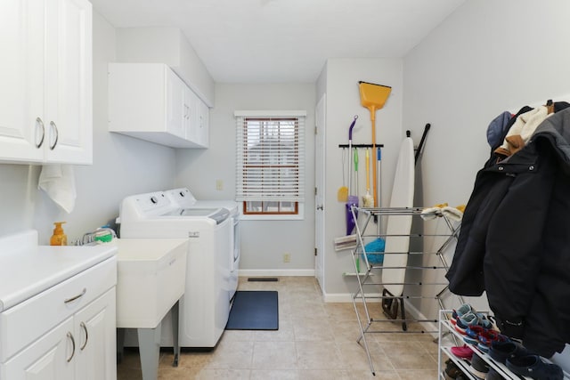 laundry area featuring cabinet space, washer and clothes dryer, baseboards, and light tile patterned floors