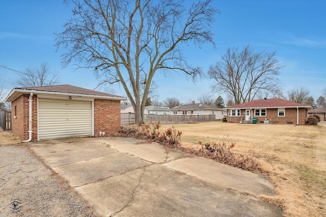 view of yard with a garage, fence, driveway, and an outdoor structure