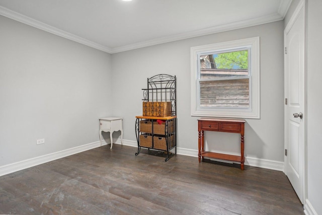 empty room featuring crown molding, baseboards, and wood finished floors