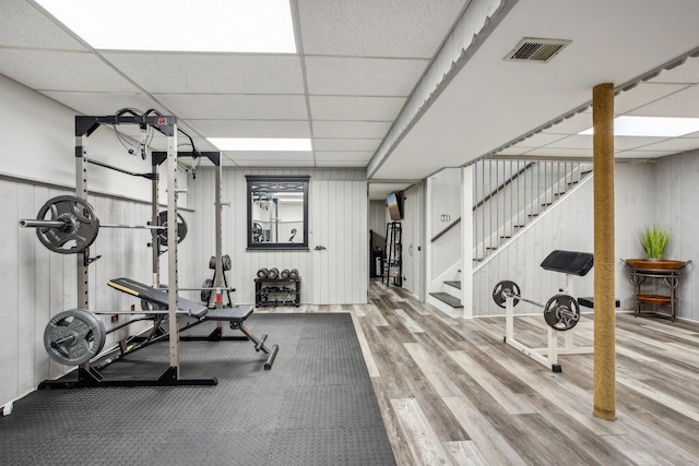 workout room featuring visible vents, a drop ceiling, and wood finished floors