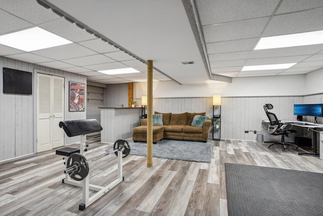 home office with visible vents, a drop ceiling, wood finished floors, and wainscoting