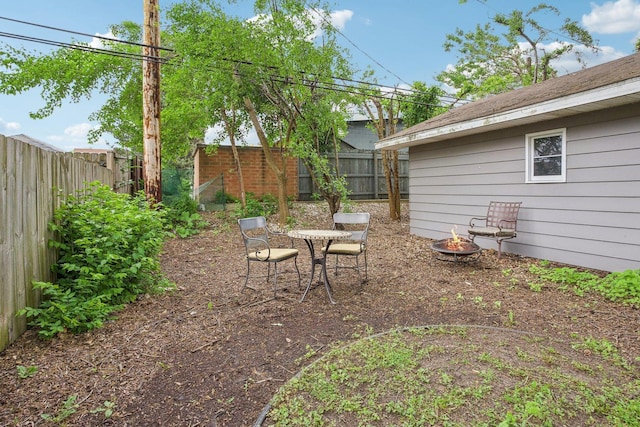 view of yard featuring an outdoor fire pit and a fenced backyard