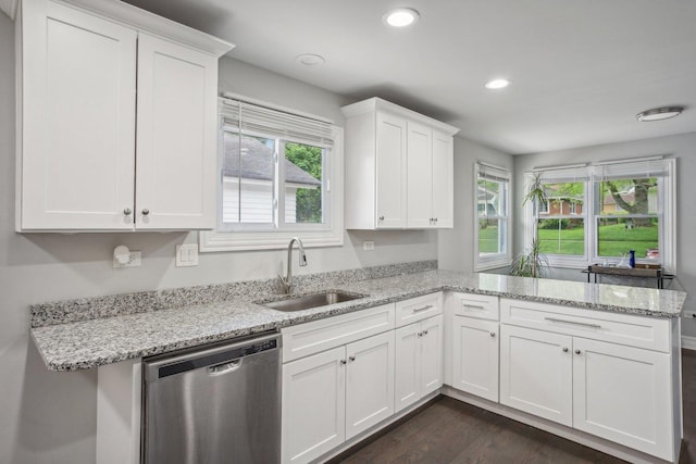 kitchen featuring white cabinets, dishwasher, dark wood-style flooring, a peninsula, and a sink