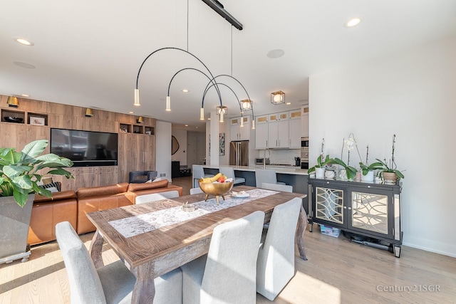 dining space featuring light wood finished floors, baseboards, and recessed lighting