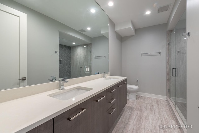 full bath with toilet, double vanity, a sink, and visible vents