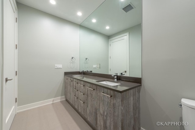 bathroom with recessed lighting, a sink, visible vents, and baseboards