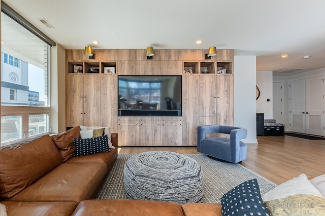 living room with recessed lighting, visible vents, and light wood finished floors