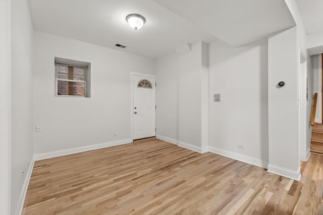 unfurnished room featuring light wood-type flooring, baseboards, and visible vents