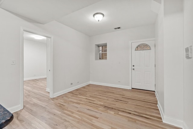 interior space featuring baseboards, visible vents, and light wood finished floors