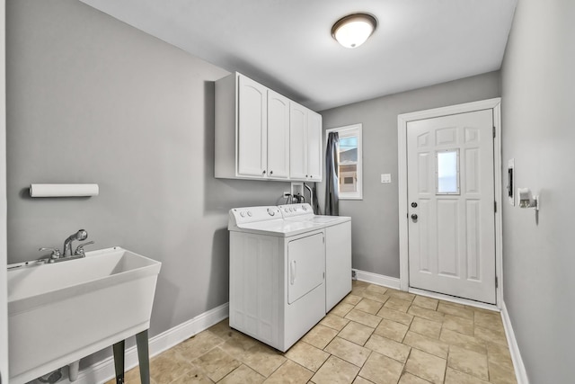 laundry room featuring cabinet space, a sink, washer and clothes dryer, and baseboards