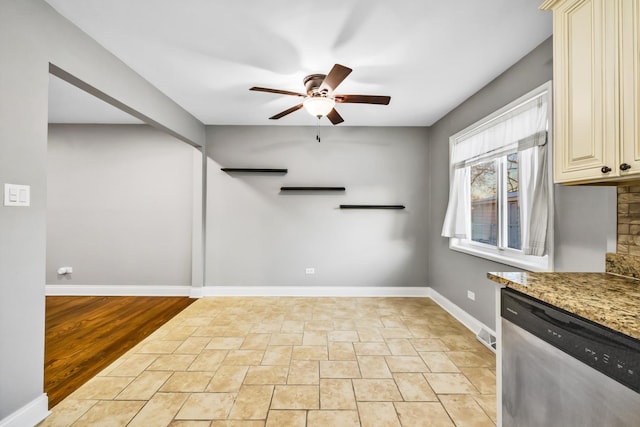 kitchen featuring ceiling fan, light stone counters, baseboards, cream cabinetry, and dishwasher