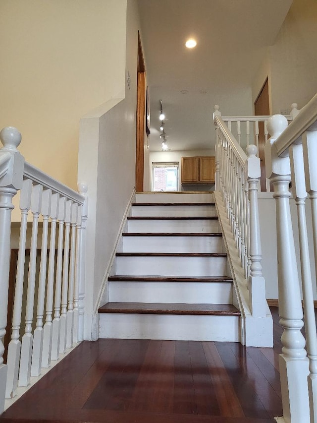 stairway with wood finished floors and recessed lighting