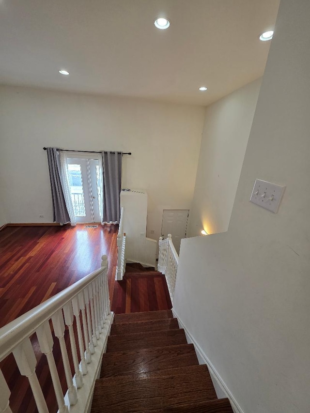 staircase with recessed lighting and wood finished floors