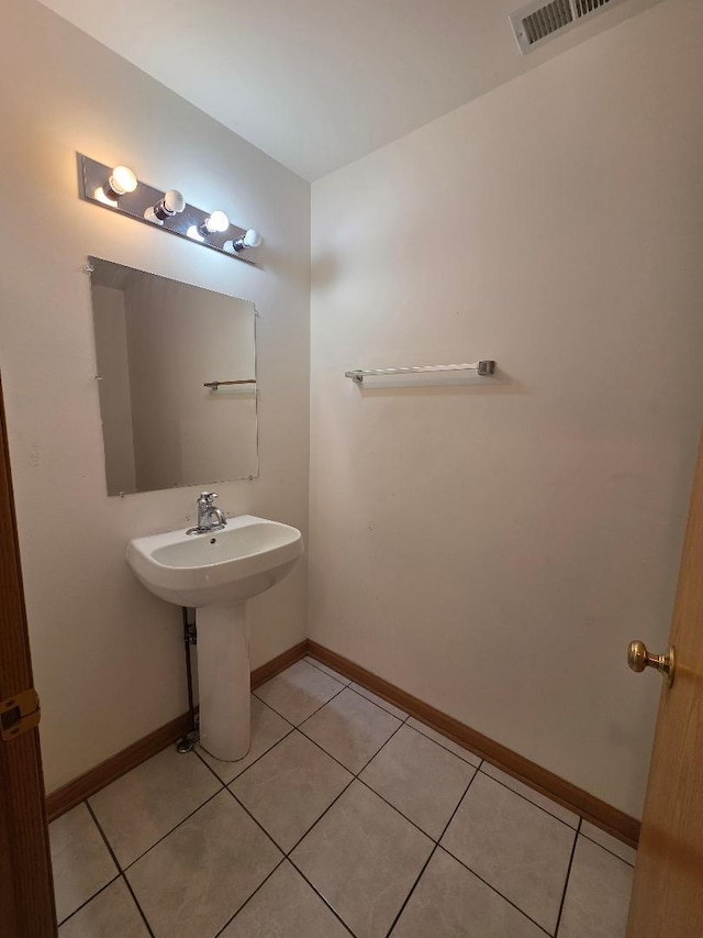 bathroom featuring a sink, tile patterned flooring, visible vents, and baseboards