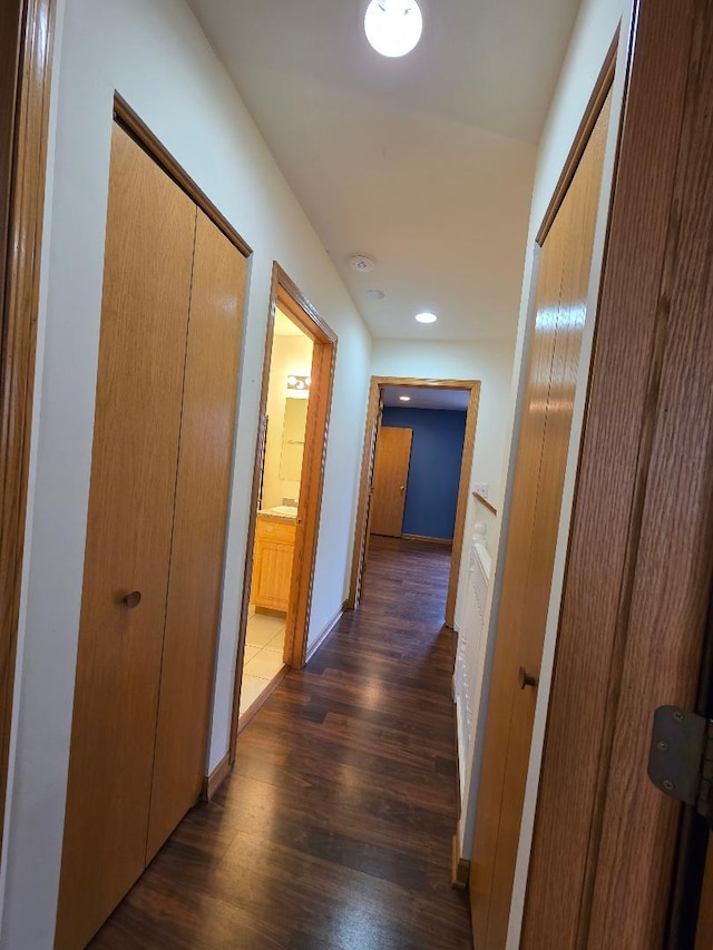 hallway featuring recessed lighting, dark wood finished floors, and baseboards