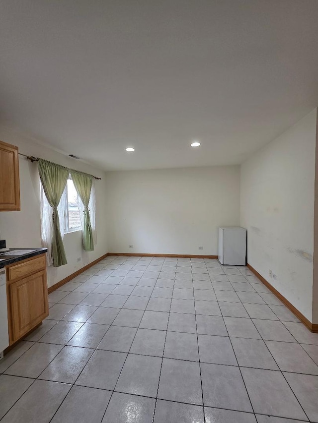 empty room featuring recessed lighting, baseboards, and light tile patterned flooring