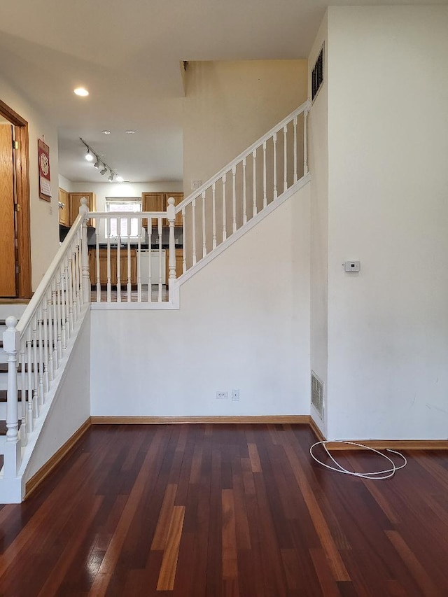 interior space with dark wood-style floors, stairway, and baseboards