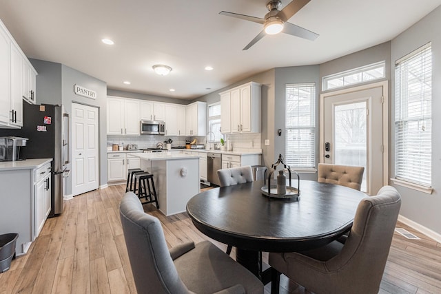 dining room with ceiling fan, recessed lighting, light wood-style flooring, and baseboards