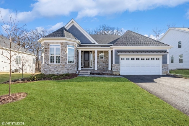 view of front of property with aphalt driveway, an attached garage, a front yard, and roof with shingles