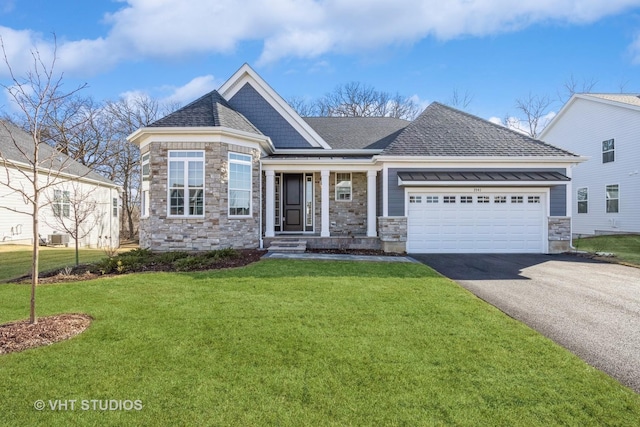 view of front of property featuring a front lawn, aphalt driveway, stone siding, an attached garage, and a shingled roof