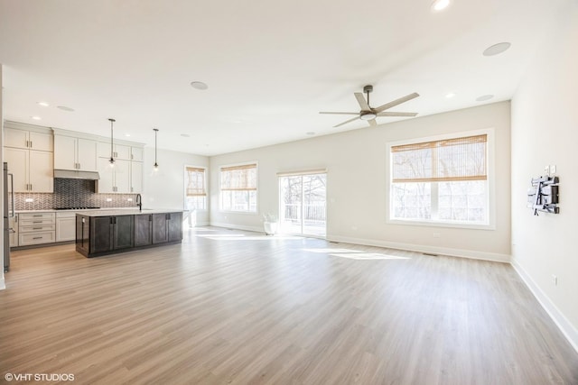 unfurnished living room featuring recessed lighting, baseboards, light wood-type flooring, and ceiling fan