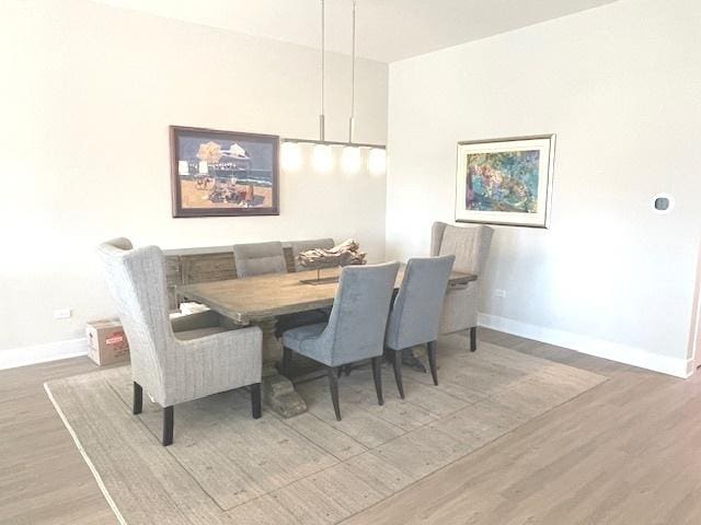 dining space with baseboards and wood finished floors