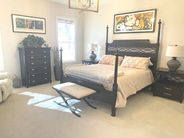 bedroom featuring light carpet and a chandelier