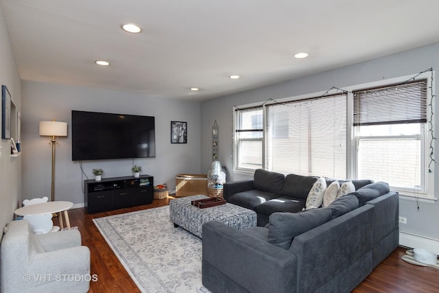 living area with recessed lighting, a baseboard heating unit, dark wood-type flooring, and baseboards