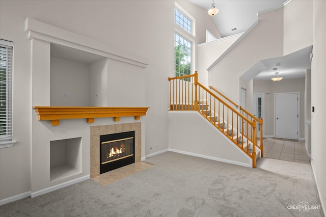 2018 Fulham Dr Unit 2018, Naperville, IL 60564 - unfurnished living room featuring carpet floors, stairway, a towering ceiling, baseboards, and a fireplace