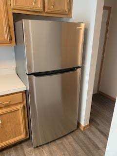 kitchen featuring baseboards, light countertops, freestanding refrigerator, and light wood-style floors