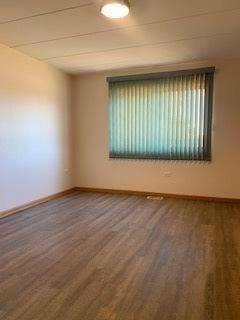 empty room featuring baseboards and wood finished floors