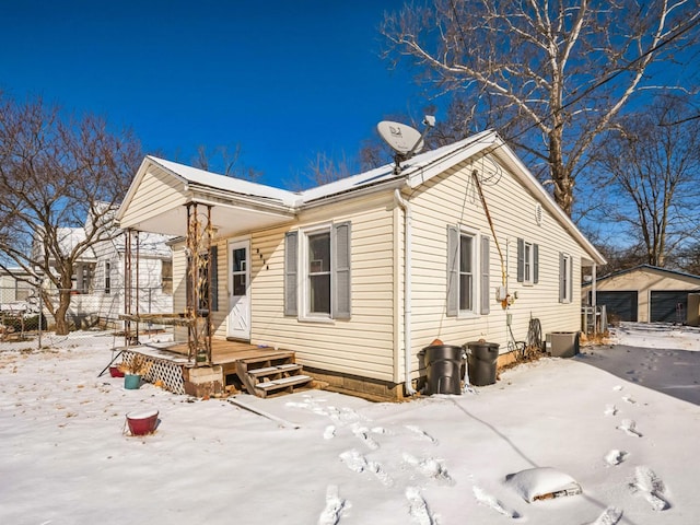 exterior space featuring a garage and an outbuilding