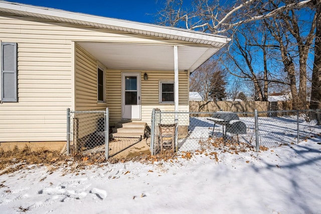 snow covered property entrance with fence