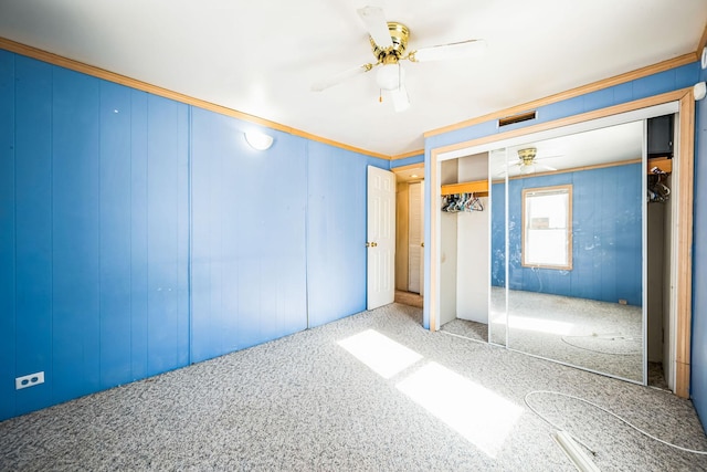 unfurnished bedroom featuring carpet flooring, visible vents, a ceiling fan, ornamental molding, and a closet