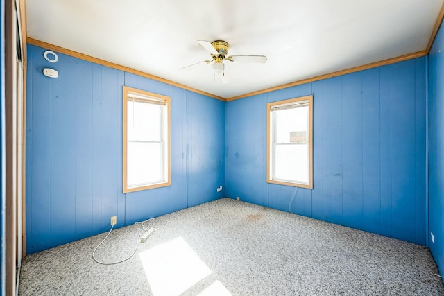 carpeted spare room with a ceiling fan and plenty of natural light