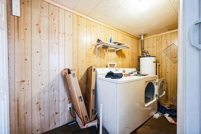 laundry room featuring laundry area, washer / clothes dryer, gas water heater, and wood walls