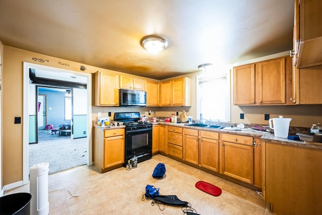 kitchen featuring a wealth of natural light, stainless steel microwave, a sink, and gas stove