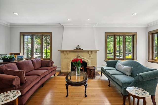 living area featuring light wood-type flooring, french doors, a fireplace, and crown molding