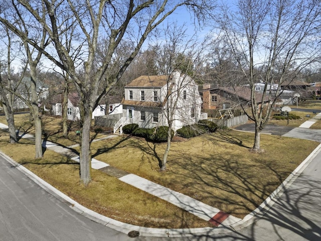 view of front of home with a front yard and fence