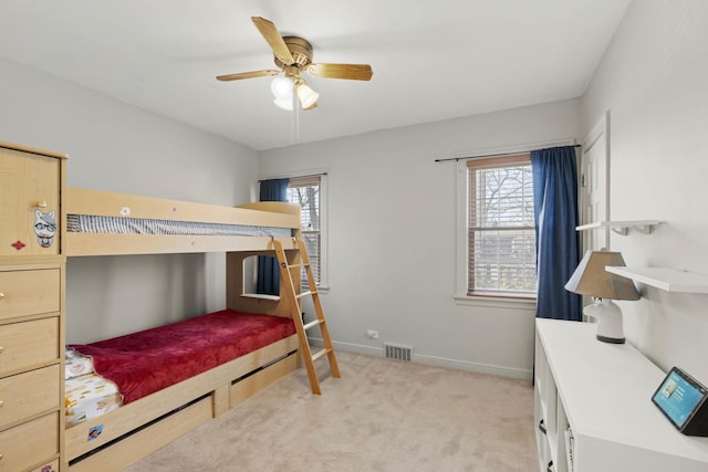 bedroom featuring light carpet, visible vents, multiple windows, and baseboards