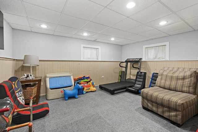 exercise room with recessed lighting, a wainscoted wall, and a paneled ceiling