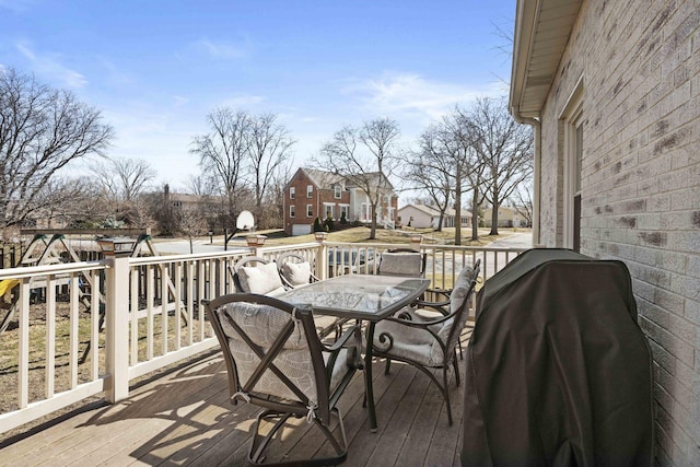 wooden deck featuring a grill and outdoor dining space