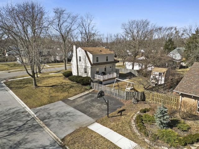 back of house with a fenced front yard, a gambrel roof, roof with shingles, and a chimney