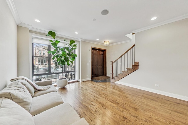 living area with crown molding, baseboards, light wood-type flooring, stairs, and recessed lighting