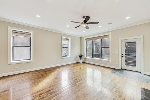 spare room featuring recessed lighting, crown molding, baseboards, and wood finished floors