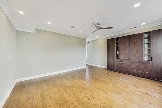 spare room featuring a ceiling fan, baseboards, light wood-style floors, and crown molding