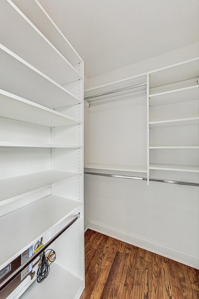 walk in closet with wood finished floors