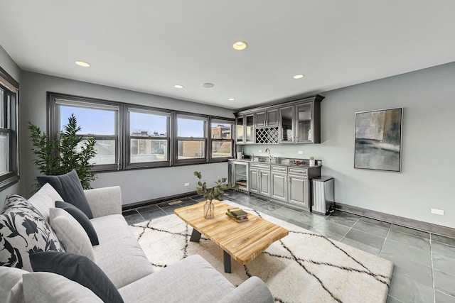 living area featuring indoor wet bar, recessed lighting, and baseboards