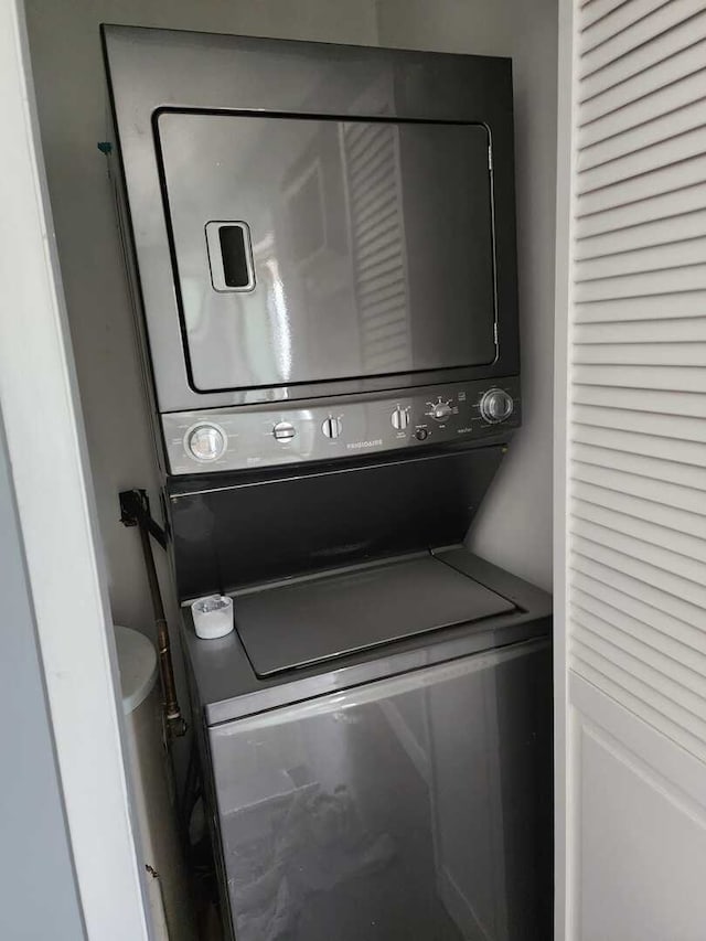 washroom with laundry area and stacked washing maching and dryer